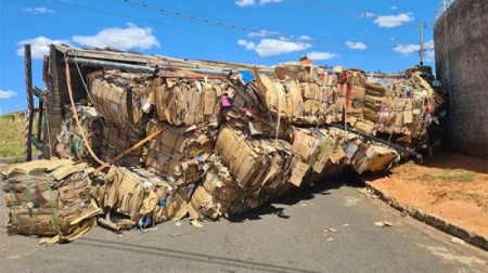 Caminhão com carga de papelão tomba; motorista não se feriu